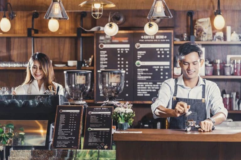 Barista preparing cup of coffee, espresso with latte or cappuccino for customer order in coffee shop