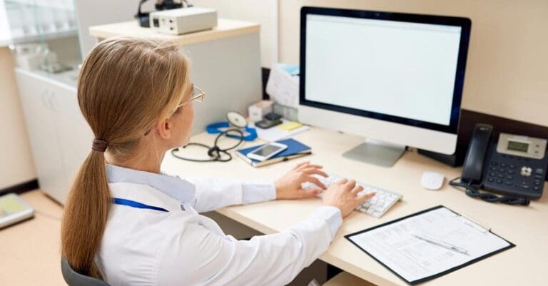 Doctor typing on computer in medical office