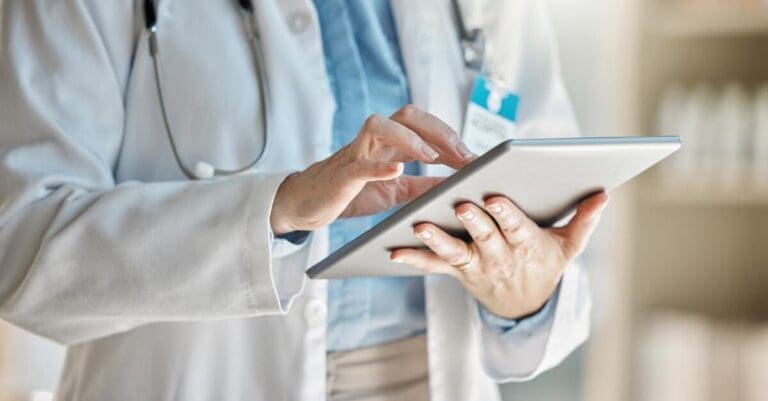 Doctor or medical personnel holding tablet viewing patient information